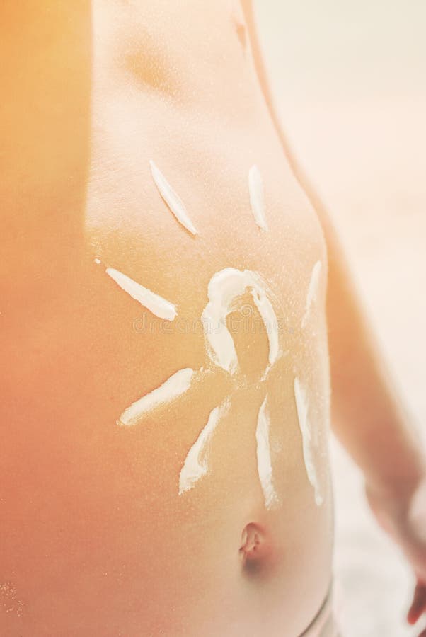 La muestra Sun brilla la piel sana del bronceado del niño del estómago fotos de archivo La muestra Sun brilla la piel sana del bronceado del niño del estómago fotos de archivo
