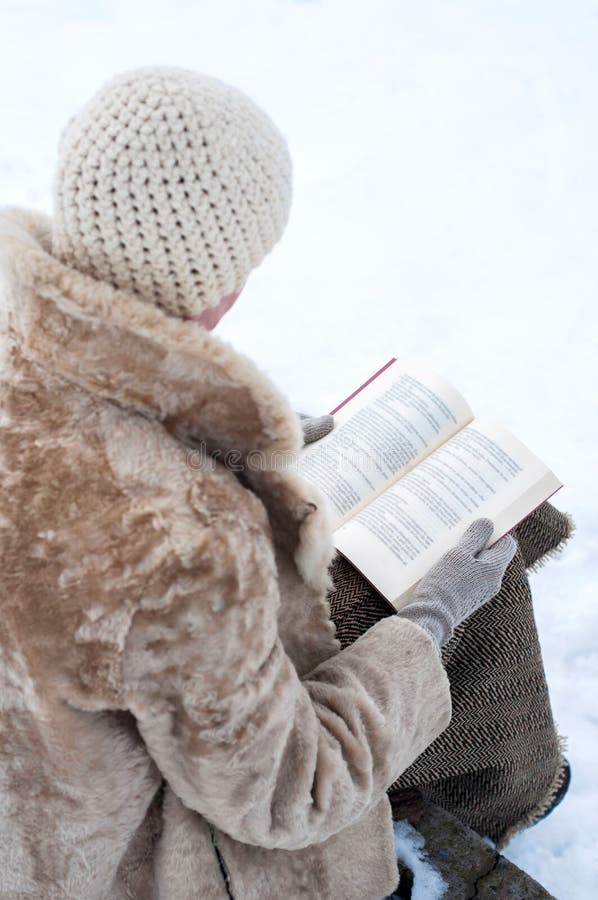 La mujer alista un libro en invierno imágenes de archivo libres de regalías La mujer alista un libro en invierno imágenes de archivo libres de regalías