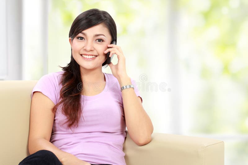 La mujer asiática feliz está llamando foto de archivo La mujer asiática feliz está llamando foto de archivo