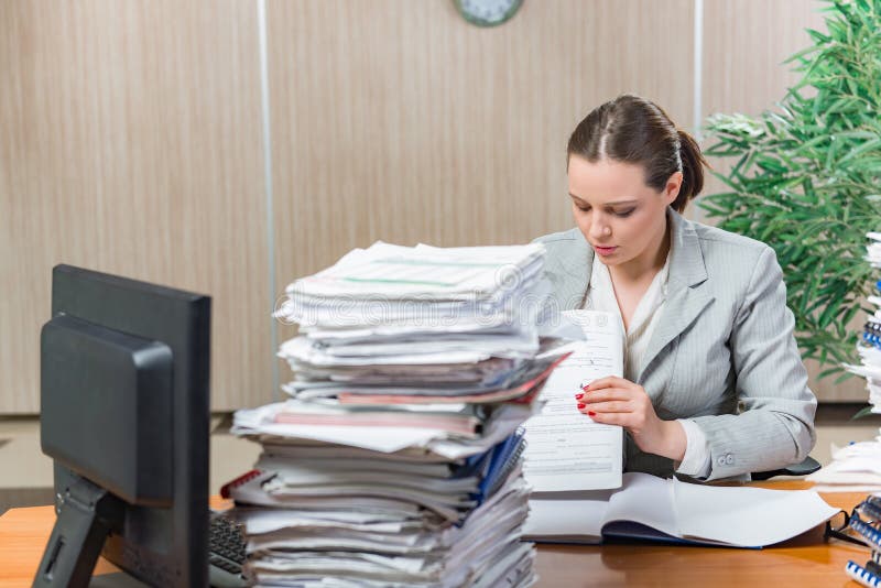 La mujer bajo tensión del papeleo excesivo foto de archivo La mujer bajo tensión del papeleo excesivo foto de archivo