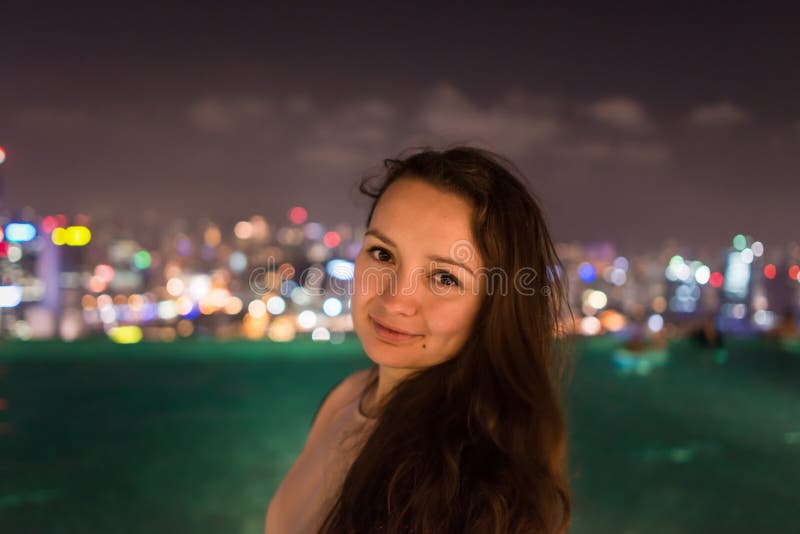 La mujer bastante joven se está colocando en el tejado de Marina Bay Sands imagen de archivo libre de regalías La mujer bastante joven se está colocando en el tejado de Marina Bay Sands imagen de archivo libre de regalías