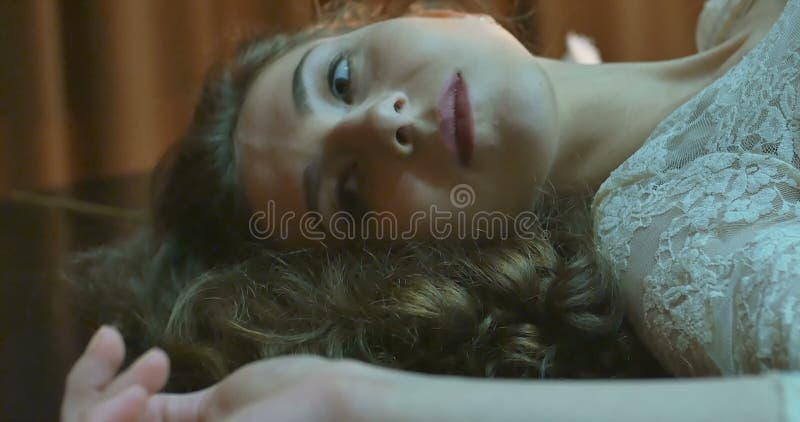 La mujer bonita en vestido miente en piano de cola negro almacen de metraje de vídeo