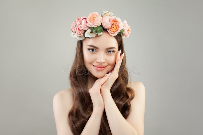 La mujer bonita joven con la piel clara, el pelo sano y las flores enrruellan foto de archivo La mujer bonita joven con la piel clara, el pelo sano y las flores enrruellan foto de archivo