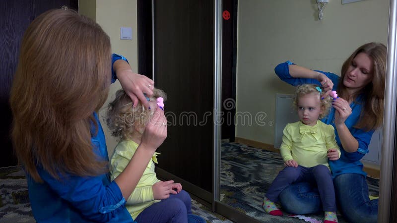 La mujer cariñosa puso resbala dentro de su pelo de la muchacha de la hija