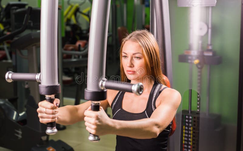 La mujer caucásica de la aptitud se está resolviendo en la máquina de la mariposa en gimnasio fotos de archivo libres de regalías La mujer caucásica de la aptitud se está resolviendo en la máquina de la mariposa en gimnasio fotos de archivo libres de regalías