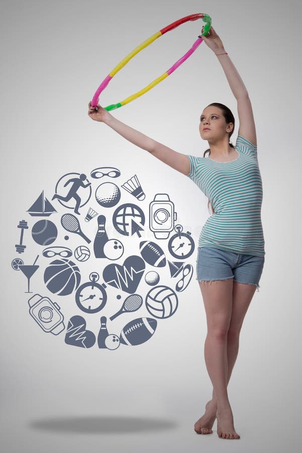 La mujer con el lazo del hula en concepto del deporte foto de archivo La mujer con el lazo del hula en concepto del deporte foto de archivo