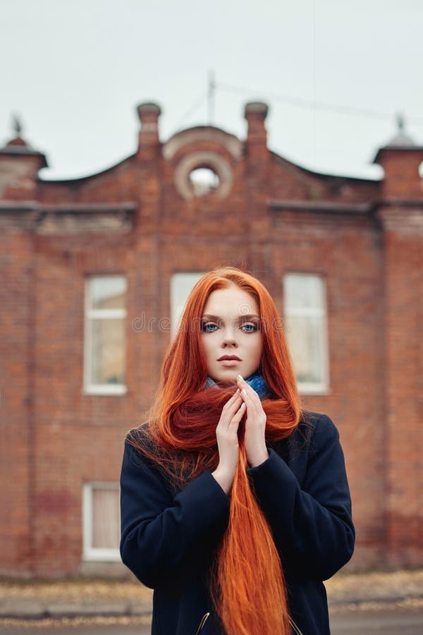 La mujer con el pelo rojo largo camina en otoño en la calle Mirada soñadora misteriosa y la imagen de la muchacha El caminar de l foto de archivo libre de regalías La mujer con el pelo rojo largo camina en otoño en la calle Mirada soñadora misteriosa y la imagen de la muchacha El caminar de l foto de archivo libre de regalías