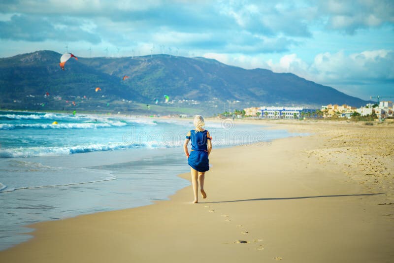 La mujer corre en la playa arenosa imágenes de archivo libres de regalías La mujer corre en la playa arenosa imágenes de archivo libres de regalías