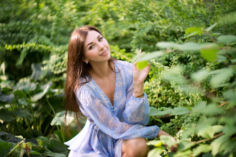 La mujer de Bunette que se sienta en hierba en jardín, se relaja fotos de archivo La mujer de Bunette que se sienta en hierba en jardín, se relaja fotos de archivo