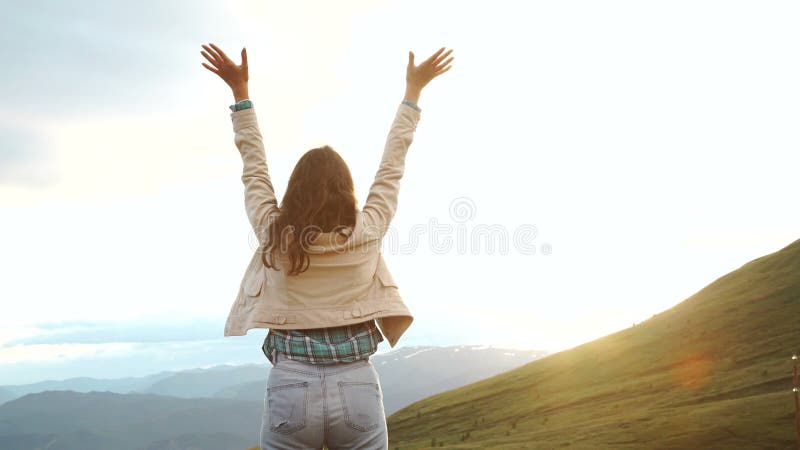 La mujer de celebración feliz del éxito que ganaba en la colocación de la puesta del sol o de la salida del sol regocijó con los