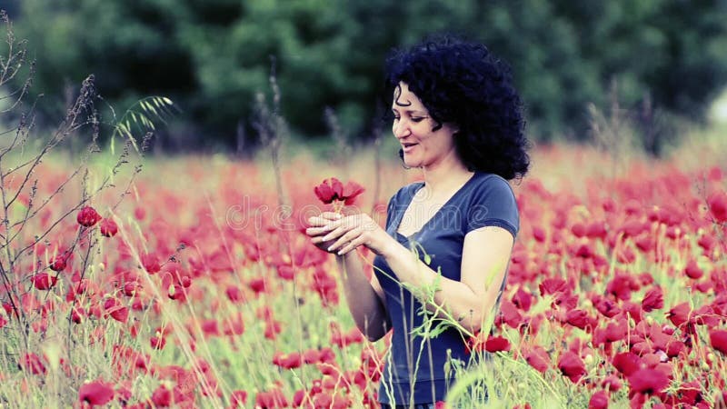 La mujer de la primavera huele el vintage de las flores de la amapola