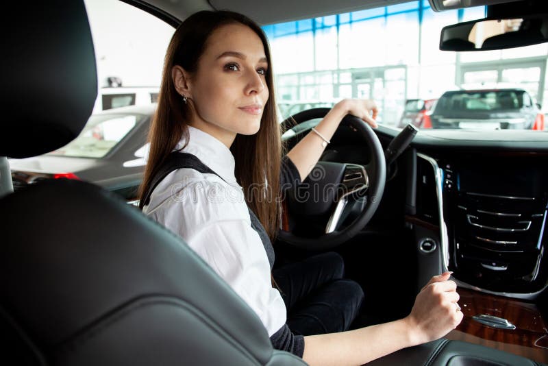 La mujer de negocios joven prueba su nuevo coche fotos de archivo libres de regalías La mujer de negocios joven prueba su nuevo coche fotos de archivo libres de regalías