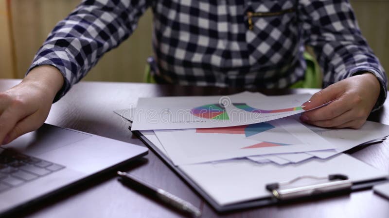 La mujer de negocios utiliza su ordenador portátil para conseguir los resultados finales de la compañía metrajes
