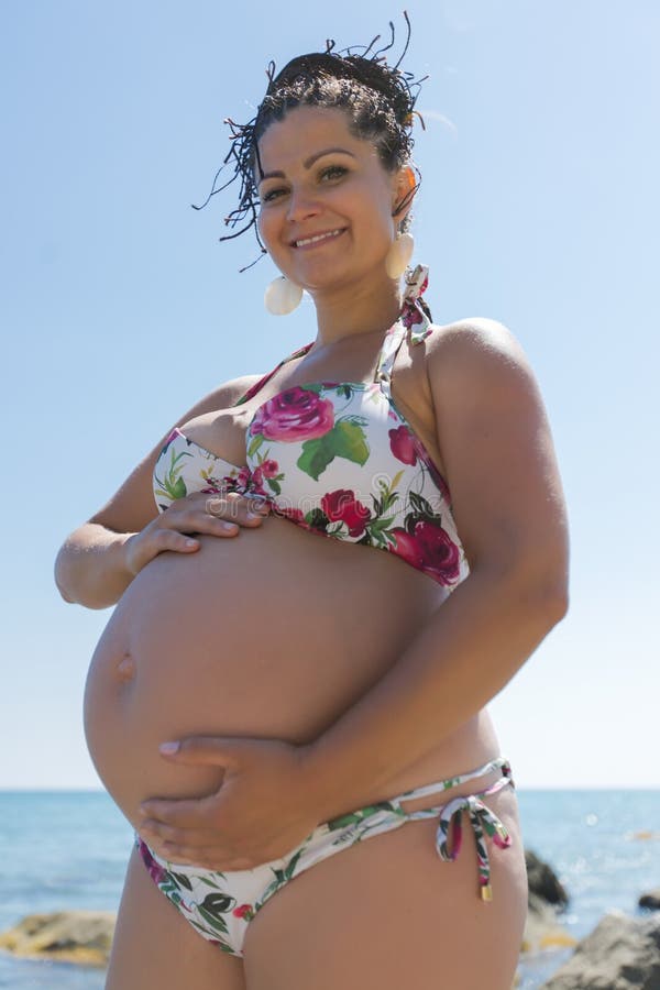 La Mujer Embarazada Atractiva En Traje De Baño Toca Para Poseer La Panza  Imagen de archivo - Imagen de lifestyle, horizonte: 83364115