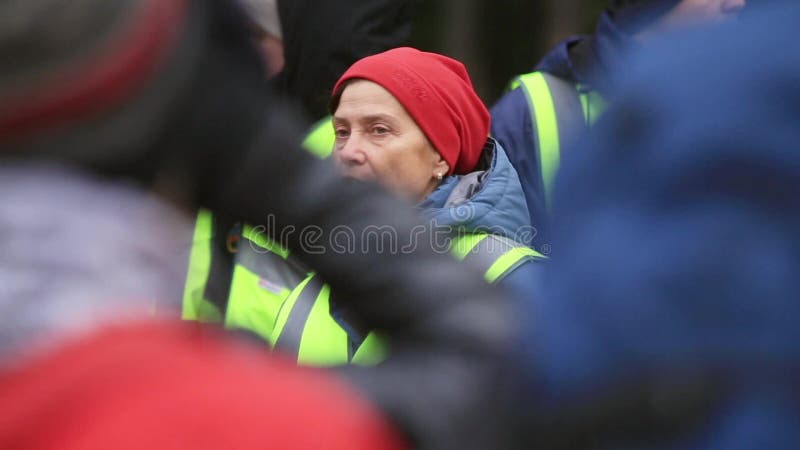 La mujer en uniforme del rescate explica algo a los salvadores jovenes en la calle enseñanza