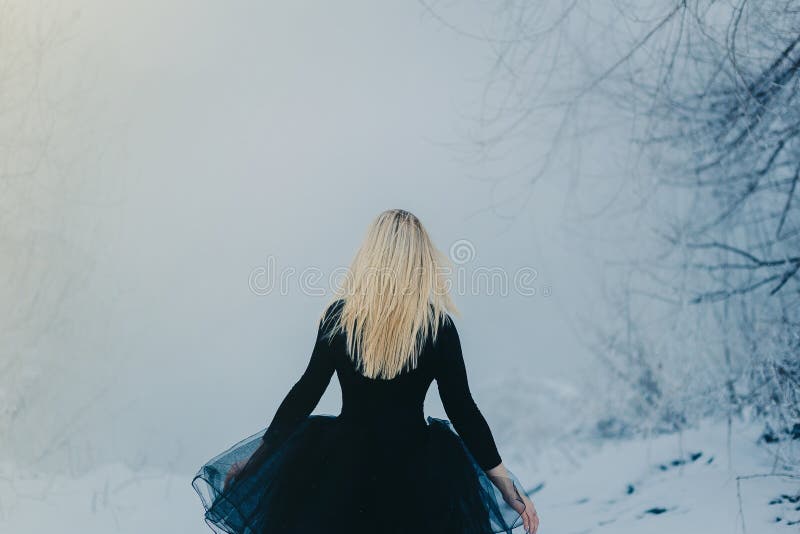 La mujer en vestido negro vuelve en la niebla imagenes de archivo La mujer en vestido negro vuelve en la niebla imagenes de archivo