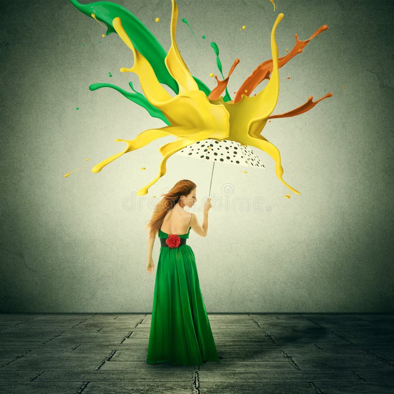 La mujer en vestido verde con el paraguas como refugio contra descensos coloridos salpica de la pintura que cae abajo foto de archivo La mujer en vestido verde con el paraguas como refugio contra descensos coloridos salpica de la pintura que cae abajo foto de archivo
