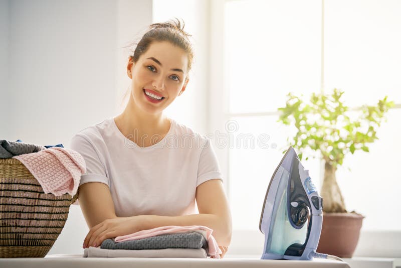 La mujer está planchando en casa imagenes de archivo La mujer está planchando en casa imagenes de archivo