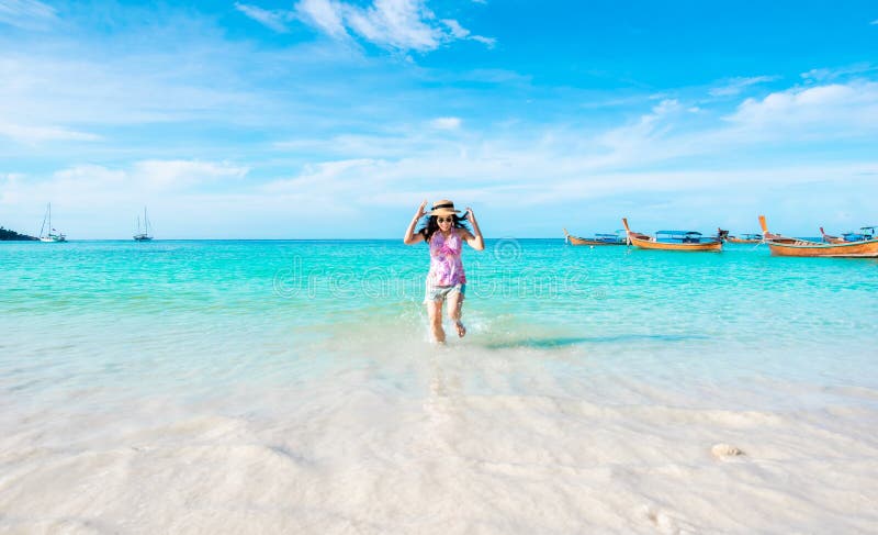 La mujer feliz que funciona con la playa y el mar tienen un verano del día de fiesta que se relaja y viajan cielo brillante imagen de archivo libre de regalías La mujer feliz que funciona con la playa y el mar tienen un verano del día de fiesta que se relaja y viajan cielo brillante imagen de archivo libre de regalías