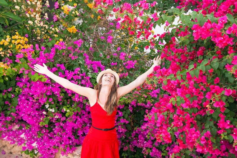 La mujer feliz se está colocando entre las flores coloridas hermosas foto de archivo La mujer feliz se está colocando entre las flores coloridas hermosas foto de archivo
