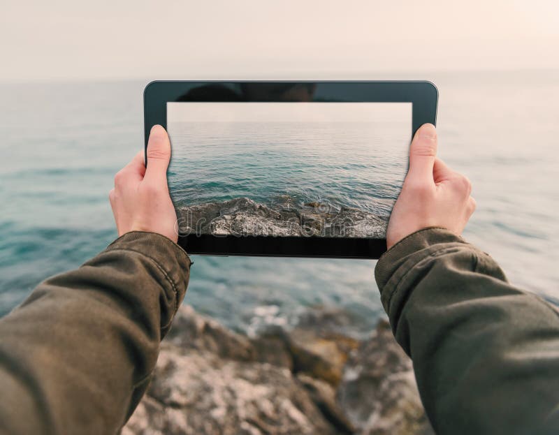 La mujer fotografía la costa en la tableta fotos de archivo libres de regalías La mujer fotografía la costa en la tableta fotos de archivo libres de regalías