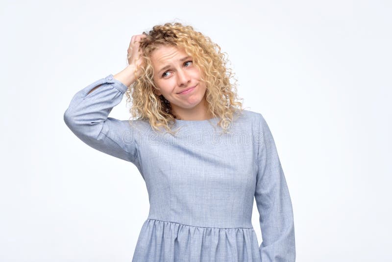 La mujer ha desconcertado la expresión facial confusa, rasguña la cabeza en la frustración foto de archivo La mujer ha desconcertado la expresión facial confusa, rasguña la cabeza en la frustración foto de archivo
