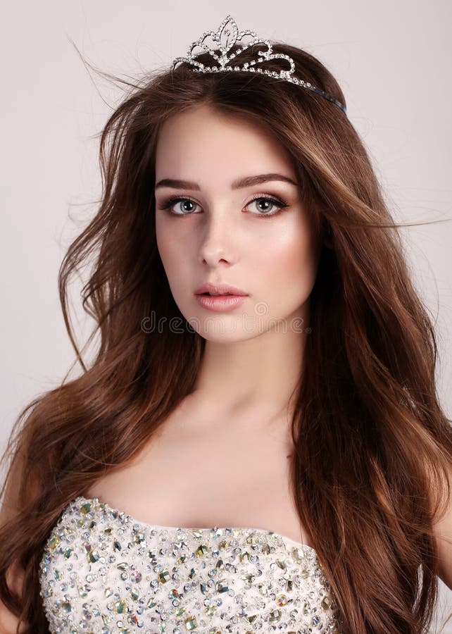 La mujer hermosa con el pelo oscuro lleva el vestido elegante y la corona preciosa fotografía de archivo libre de regalías La mujer hermosa con el pelo oscuro lleva el vestido elegante y la corona preciosa fotografía de archivo libre de regalías