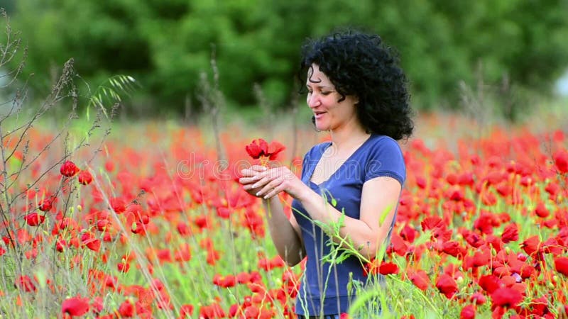 La mujer huele las flores en un campo