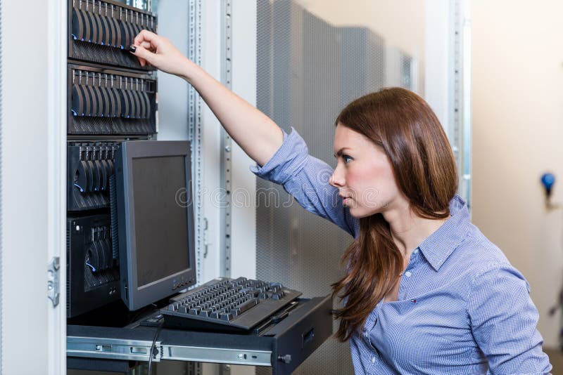 La mujer joven del ingeniero trabaja detrás de la consola de gestión fotos de archivo libres de regalías La mujer joven del ingeniero trabaja detrás de la consola de gestión fotos de archivo libres de regalías
