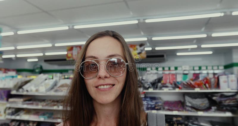 La mujer joven del retrato se coloca delante de la cámara y de las sonrisas almacen de video