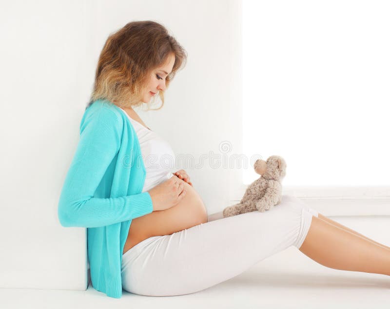 La mujer joven embarazada feliz piensa y sueña con un niño futuro fotos de archivo La mujer joven embarazada feliz piensa y sueña con un niño futuro fotos de archivo