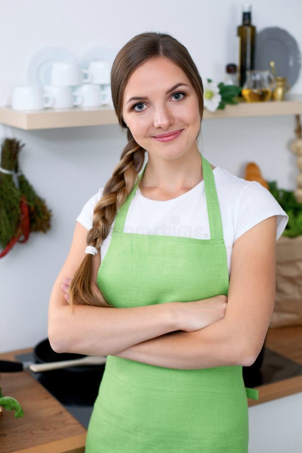 La Mujer Joven En Delantal Verde Va Para Cocinar En Una Cocina Foto de  archivo - Imagen de alegre, trenza: 101944536