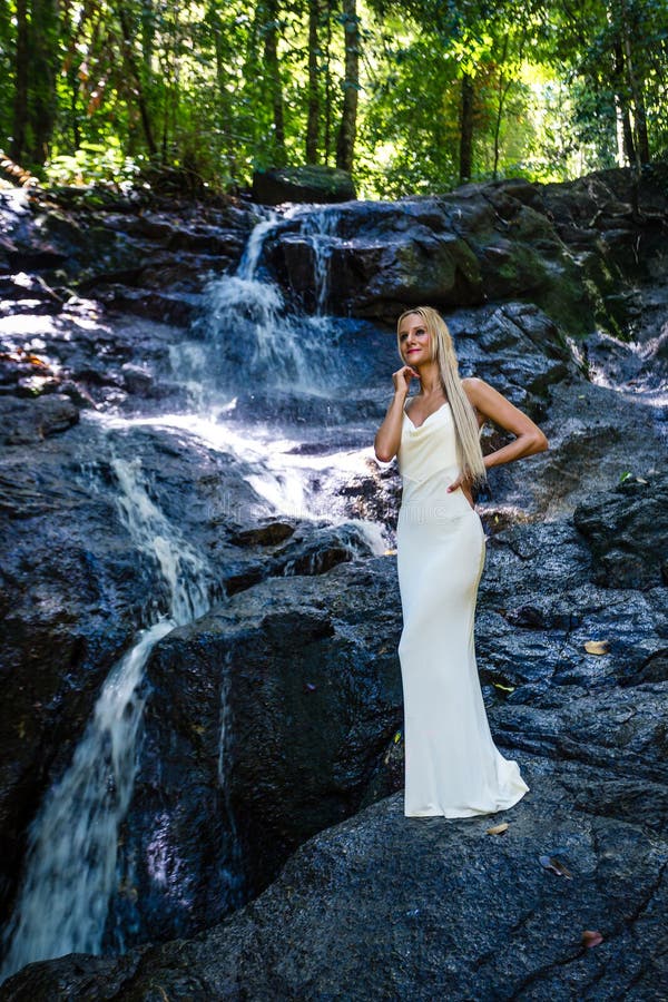 La Mujer Joven En El Vestido Blanco Está Presentando En La Cascada Foto de archivo - Imagen de sano, lifestyle: 141828948 La Mujer Joven En El Vestido Blanco Está Presentando En La Cascada Foto de archivo - Imagen de sano, lifestyle: 141828948