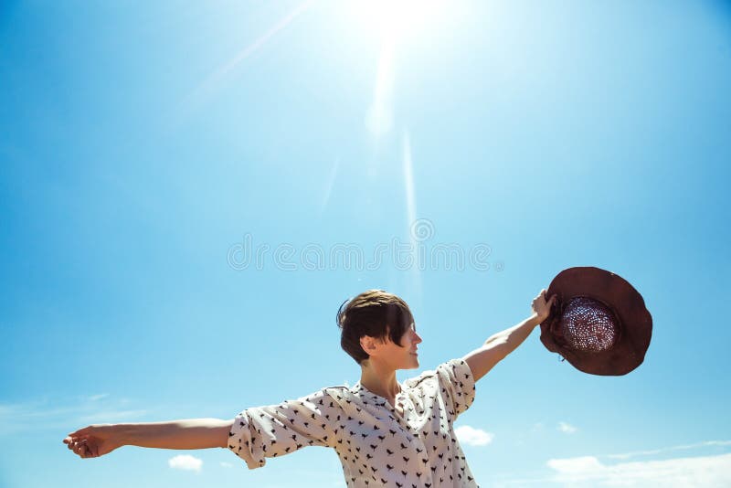 La mujer joven en sombrero que disfrutaba de tiempo de verano aumentó las manos viaja turista al aire libre de la muchacha de la imágenes de archivo libres de regalías La mujer joven en sombrero que disfrutaba de tiempo de verano aumentó las manos viaja turista al aire libre de la muchacha de la imágenes de archivo libres de regalías