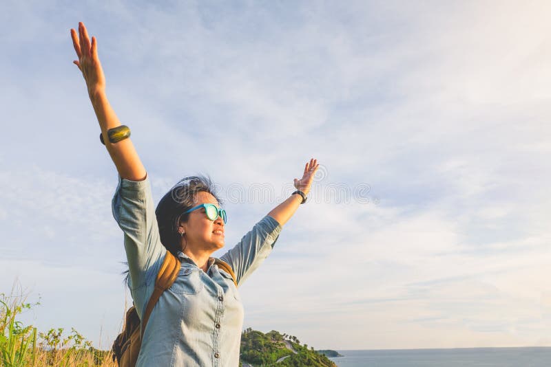 La mujer joven feliz del viajero aumentó el brazo hasta el cielo que gozaba de un beaut imagenes de archivo La mujer joven feliz del viajero aumentó el brazo hasta el cielo que gozaba de un beaut imagenes de archivo
