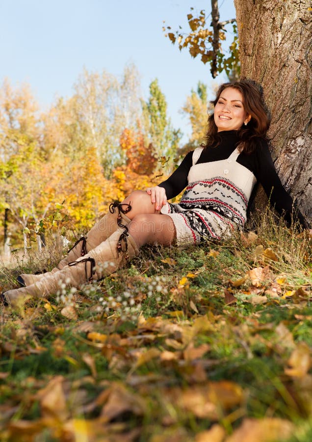 La mujer joven feliz se relaja en parque foto de archivo La mujer joven feliz se relaja en parque foto de archivo