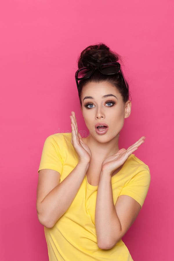 La mujer joven hermosa sorprendida se está sosteniendo principal en manos fotografía de archivo La mujer joven hermosa sorprendida se está sosteniendo principal en manos fotografía de archivo