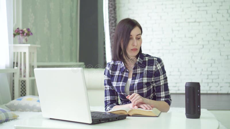 La mujer joven que estudia, usando un ayudante de la voz, tiene una pregunta