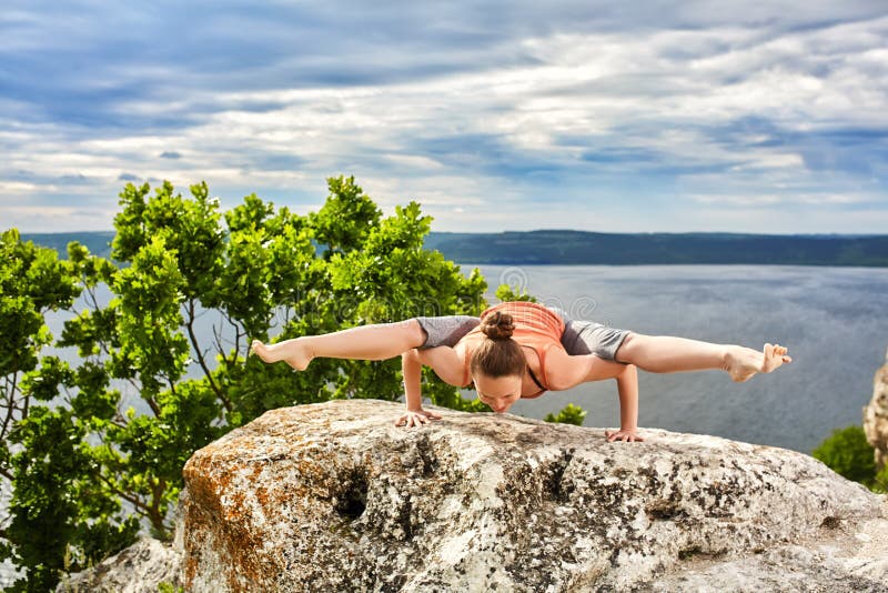 La mujer joven que hace aptitud de la yoga ejercita al aire libre en paisaje del río fotografía de archivo La mujer joven que hace aptitud de la yoga ejercita al aire libre en paisaje del río fotografía de archivo