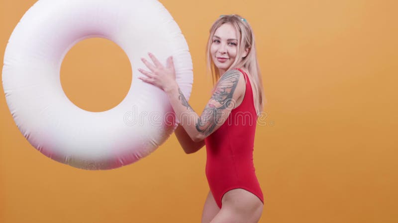 La mujer joven rubia con un anillo de la nadada baila en la cámara lenta metrajes