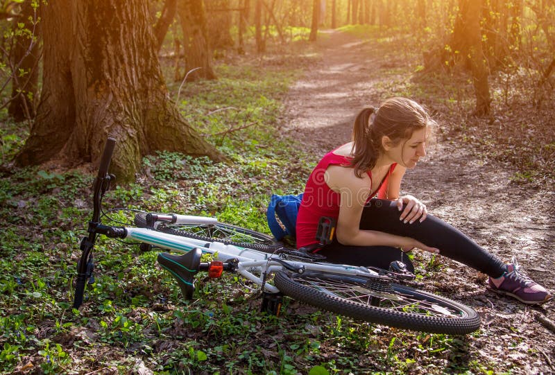 La mujer joven se cayó de la bicicleta fotografía de archivo libre de regalías La mujer joven se cayó de la bicicleta fotografía de archivo libre de regalías