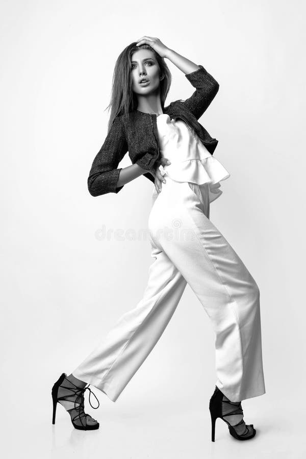 acoso Explícitamente alto La Mujer Joven Se Vistió En La Ropa Blanca Y La Chaqueta Azul Que  Presentaban En Estudio En Un Fondo Blanco Foto Blanco Y Negro D Imagen de  archivo - Imagen de