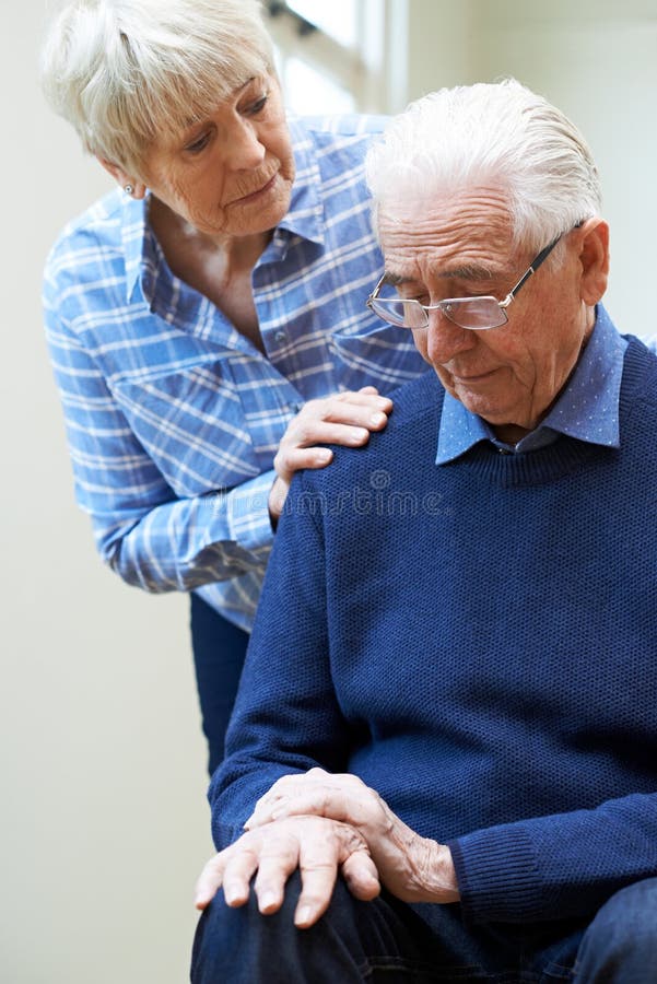 La mujer mayor conforta al marido que sufre con Parkinsons Diesease fotografía de archivo La mujer mayor conforta al marido que sufre con Parkinsons Diesease fotografía de archivo