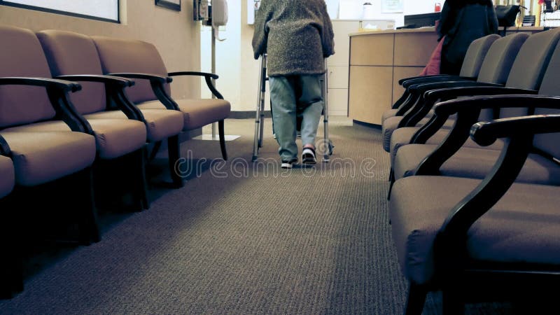 La mujer mayor utiliza a un caminante mientras que camina hacia una enfermera metrajes