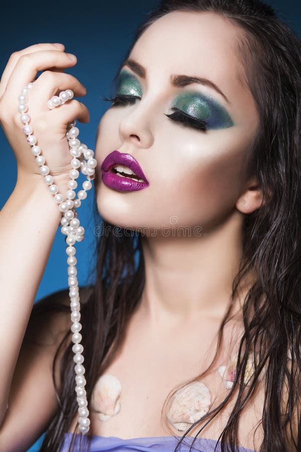 La mujer morena de la sirena con creativo compone y joyería en su cabeza hairstyled mojada imagen de archivo La mujer morena de la sirena con creativo compone y joyería en su cabeza hairstyled mojada imagen de archivo