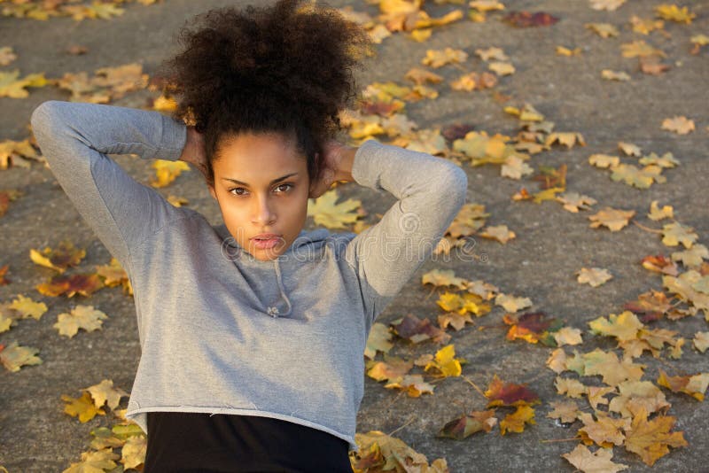 La mujer negra joven hermosa que el hacer se sienta sube imagenes de archivo La mujer negra joven hermosa que el hacer se sienta sube imagenes de archivo