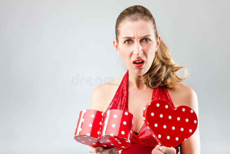 La mujer que abre el regalo y está decepcionada imágenes de archivo libres de regalías La mujer que abre el regalo y está decepcionada imágenes de archivo libres de regalías
