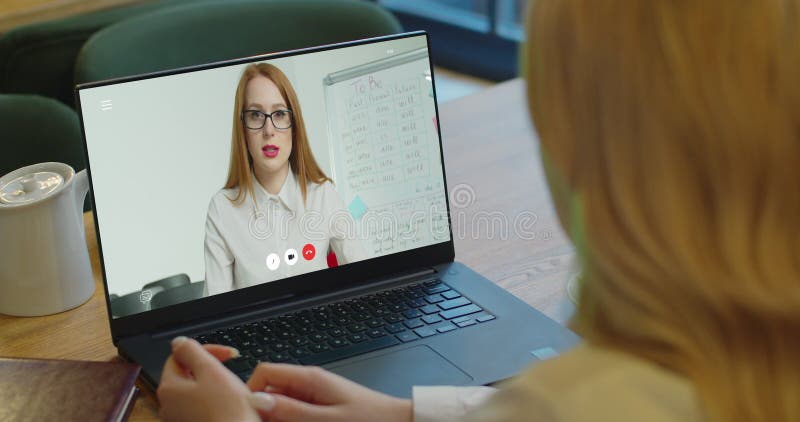 La mujer que estudia en casa la oficina en línea en conferencia que la computadora portátil de vídeo de la llamada habla comunica metrajes