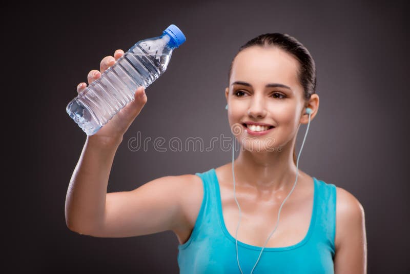 La mujer que hace deportes con la botella de agua dulce imagen de archivo La mujer que hace deportes con la botella de agua dulce imagen de archivo