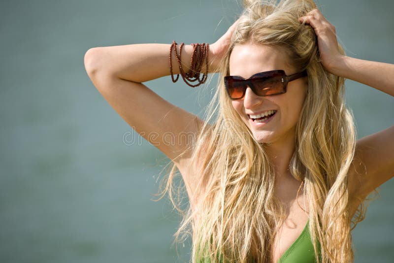 La mujer rubia feliz disfruta de día de fiesta en la orilla del lago imagen de archivo libre de regalías La mujer rubia feliz disfruta de día de fiesta en la orilla del lago imagen de archivo libre de regalías